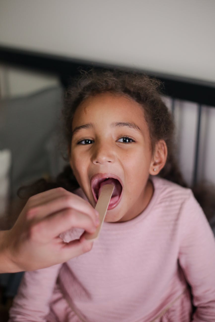 boy in pink crew neck shirt eating ice cream